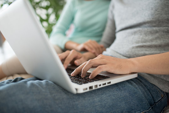 Young Asian Couple Browsing Internet At Home,using Laptop And Sm