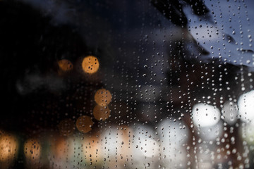 Chains of raindrops lie on the window