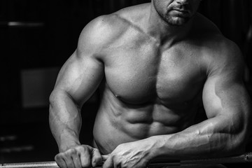 Fototapeta na wymiar Muscular and sexy torso of young man with perfect abs. Black and white