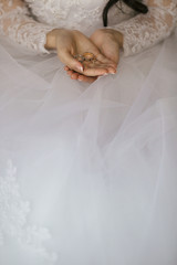 Bride holds wedding rings on her palm