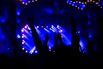 Obraz na płótnie Canvas silhouettes of concert crowd in front of bright stage lights 