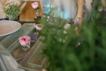 Look through the greenery at little table with pink flowers