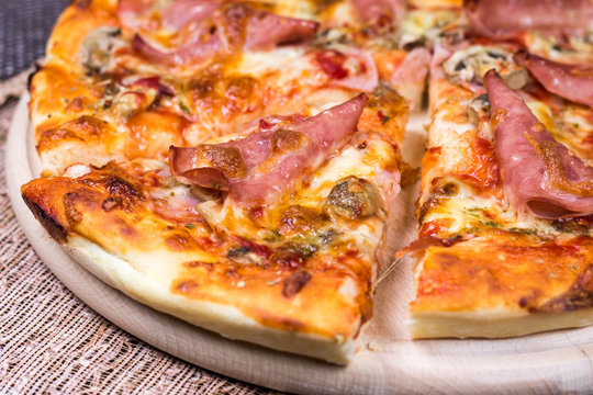 Closeup macro ham pizza on wooden board