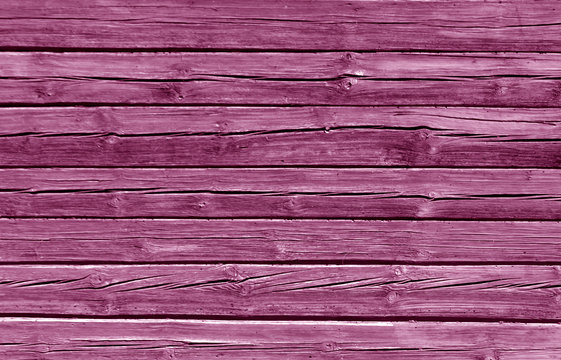 Weathered pink color log house wall.