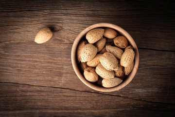 Almonds in-shell in wooden bowl.