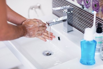 Close up of washing hands with soap under running water
