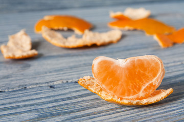 Tangerine slice and zest on wooden background