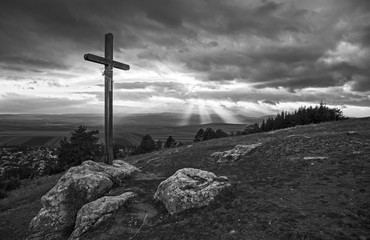 Wooden cross on hill in black and white
