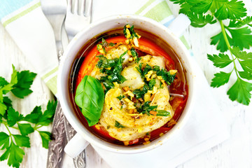 Fish baked with tomato in white bowl on board top