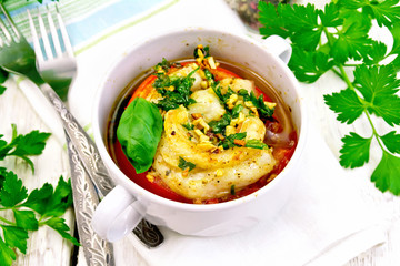 Fish baked with tomato in white bowl on board