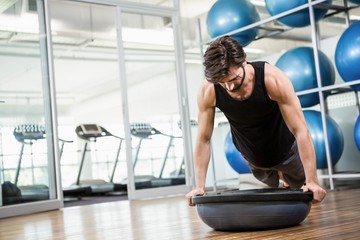 Fototapeta premium Serious man doing exercise with bosu ball