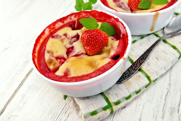 Pudding strawberry in two bowls on light board