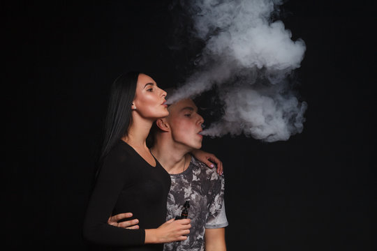 a man and woman smoking electronic cigarette