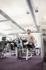 Focused man using weights machine for legs