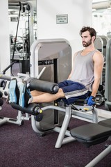 Focused man using weights machine for legs