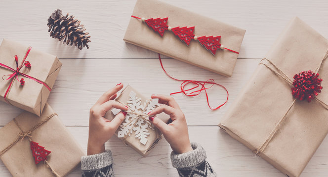 Woman's hands wrapping christmas holiday present with craft twine
