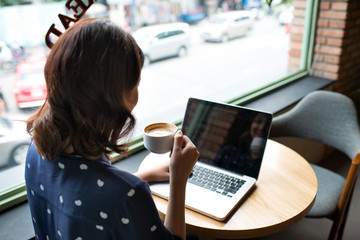 Beautiful cute asian young businesswoman in the cafe, using lapt