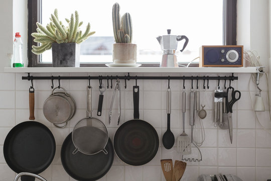 detail of a modern kitchen with pans and such hanging on a wall