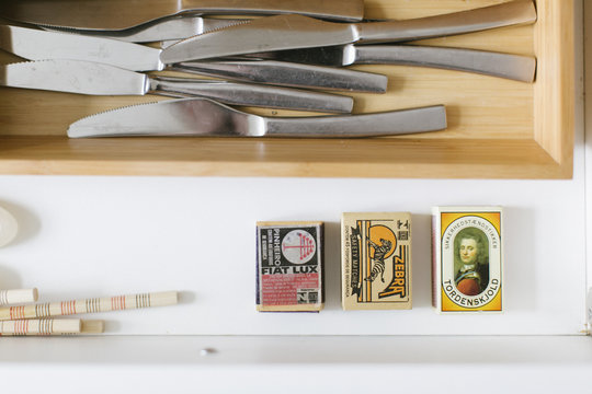 A kitchen drawer with matchboxes and knifes