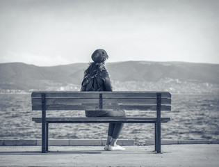 Naklejka na ściany i meble Girl on the bench near the sea.