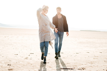 Beautiful woman and handsome man walking along seaside