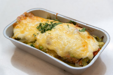 Trout baked with vegetables and cheese in batch trays