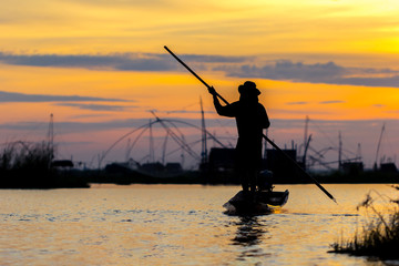 fishermen throwing net fishing in lake on morning sunrise
