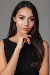 Fototapeta premium Close up portrait a brunette woman in black dress posing