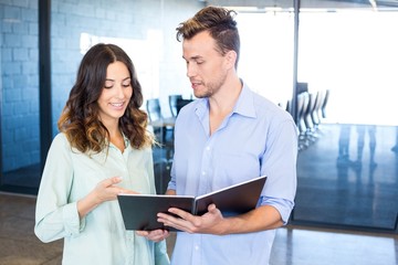 Businessman and businesswoman interacting holding organizer