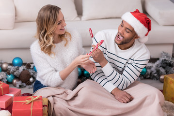 Fototapeta premium Happy nice couple exchanging lollipops