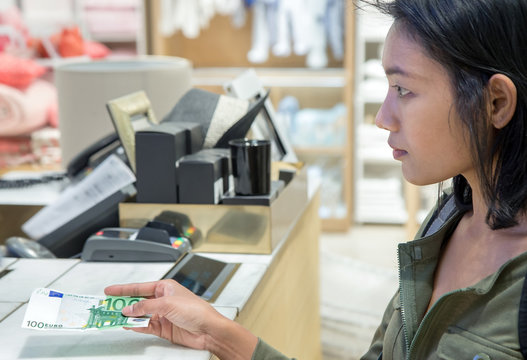 Woman pays banknote in store