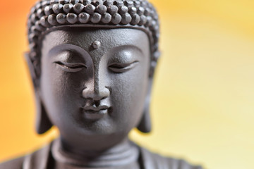 The face of Buddha Zen sculpture on a yellow background