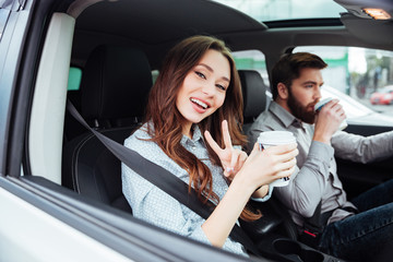 Smiling couple in car with coffee