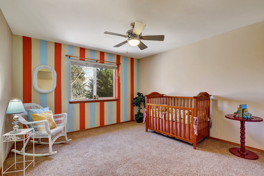 Bright Colorful Nursery Room With Contrast Striped Wall