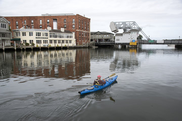 Mystic River Connecticut USA - October 2016 - Man paddling a kayak towards the Mystic River drawbrige