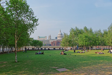 People relaxing in park at Bankside and St Paul Cathedral