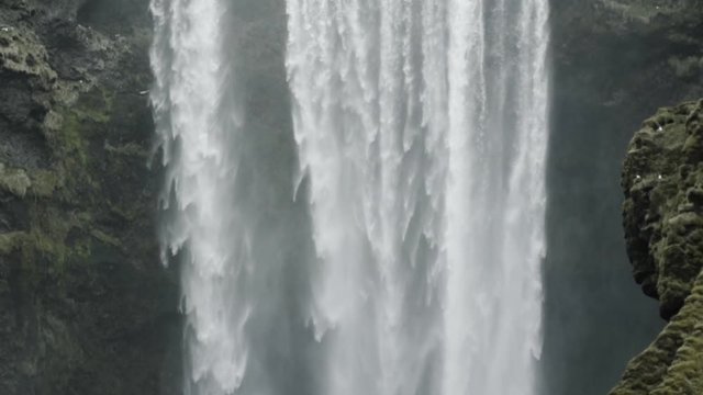 Slow motion tilt down shot of majestic Skogafoss in Iceland
