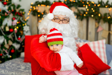 Fototapeta na wymiar little baby in the arms of Santa Claus