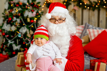 Fototapeta na wymiar little baby in the arms of Santa Claus