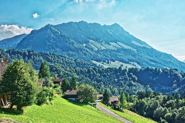 Fototapeta na wymiar Village on Prealps mountains in Gruyere district in Fribourg Switzerland