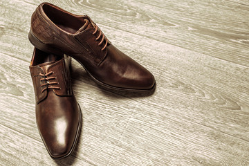 Fashion concept with male shoes on wooden background