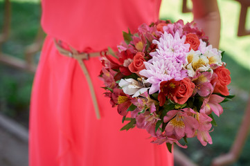 bridesmaids in a red dress with wedding bouquet