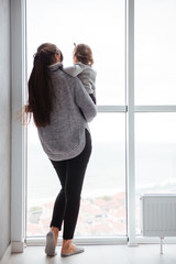 Fototapeta premium ?hild with casual mother near the window