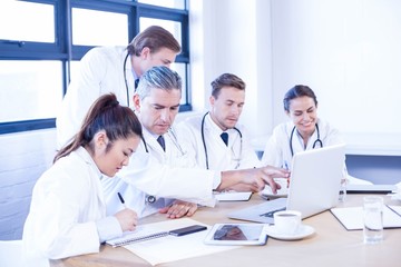 Fototapeta premium Medical team looking into laptop and having a discussion
