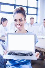 Obraz premium Portrait of female doctor showing laptop