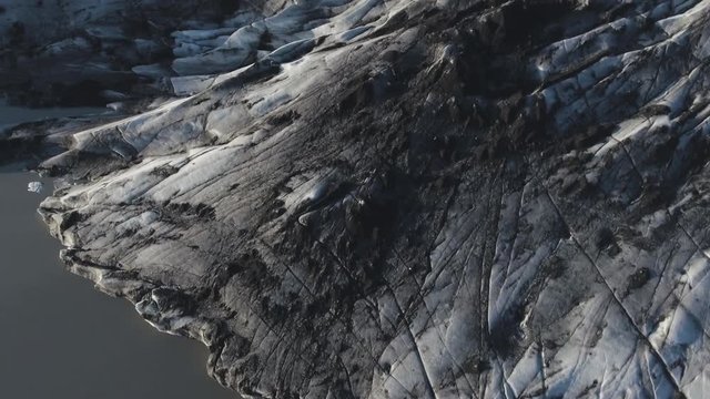 Solheimajokull glacier covered with black volcanic ash on sunny day
