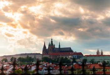 Fototapeta na wymiar Panoramic view of St. Vitus Cathedral and Castle in Prague, Czech Republic. Beautiful dramatic sunset sky with rays of making their way through clouds.