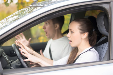 Traffic accident. Young frightened woman and a man in a car, emergency stopping, dangerous situation, driving instructor and student screaming before crash looking in windshield window