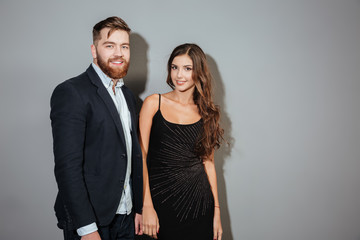 Smiling ccouple in smart wear standing and looking at camera