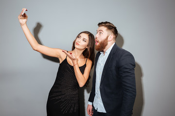 Two smiling businesspeople taking selfie with mobile phone